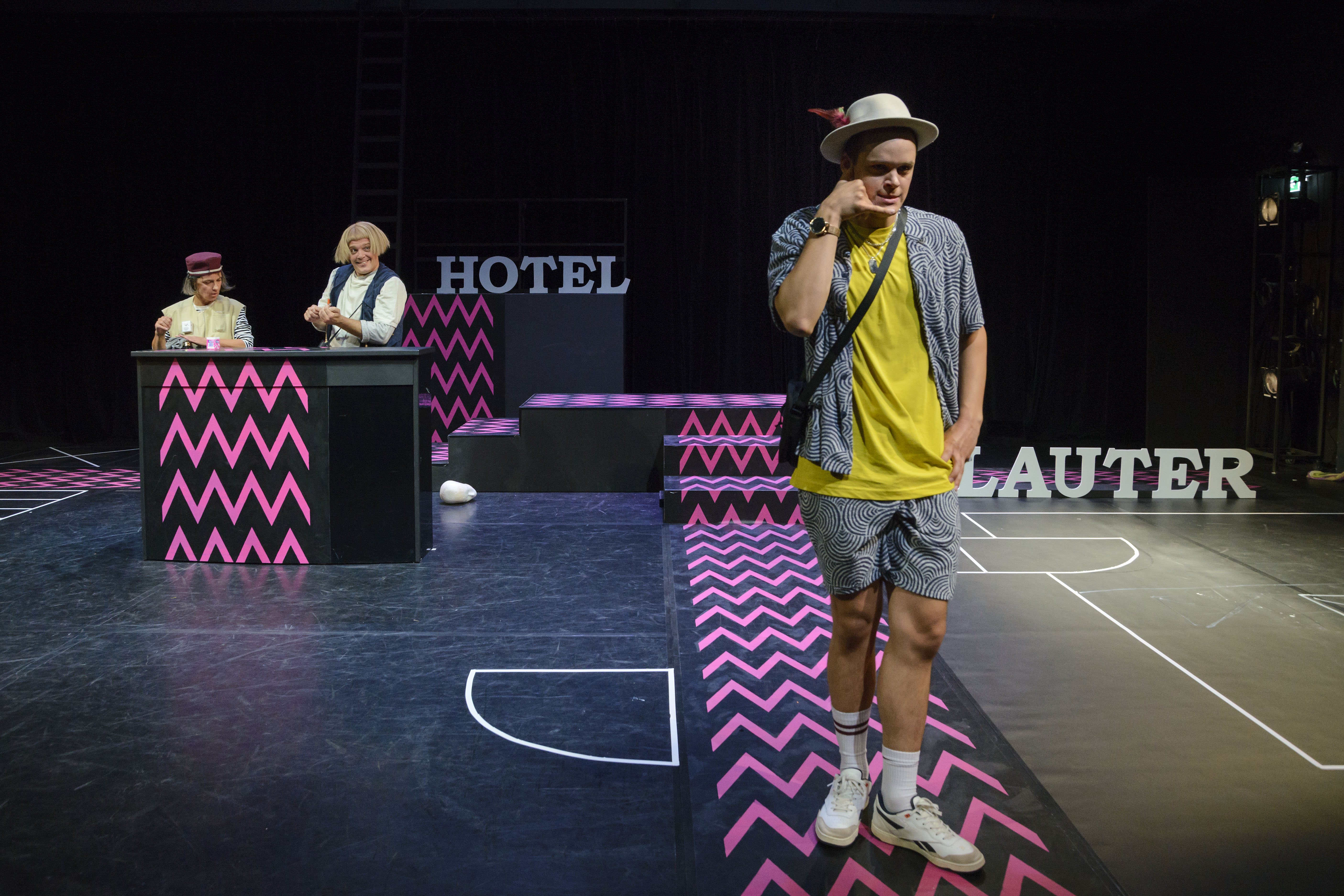 Hotel Lauter und die Unsichtbaren | Schauspiel von Armela Madreiter | 8+ | Foto: Nicolai Stephan | in Vordergrund steht Kolja Schumann als Charlie und telefoniert, im Hintergrund die beiden anderen an der Rezeption